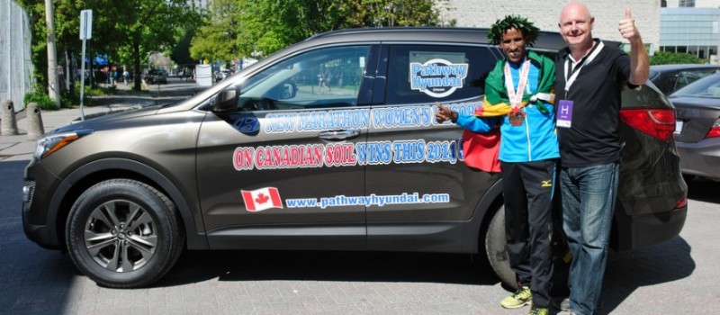 Yemane Tsegay and sponsor pose with Hyundai SUV